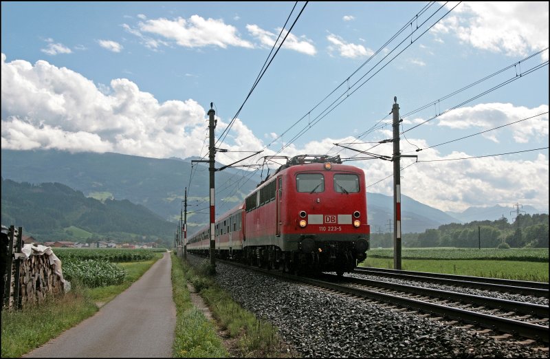 Nachdem der Regenschauer vorrber gezogen war, war 110 223 mit dem REX 5160 von Innsbruck Hbf nach Kufstein unweit von Schwaz unterwegs. (08.07.2008)
