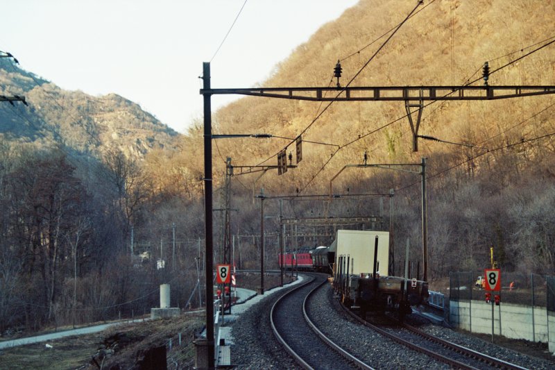 Nachschuss auf einen Gterzug mit Re 10/10 Packet, das gerade eine Baustelle durchquert.Zwischen Mezzovico und Taverrne-Torricella im Februar 2005.