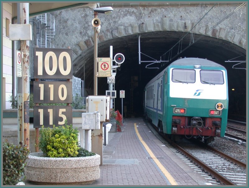 Nachschuss auf einen Interregiosteuerwagen bei der Ausfahrt aus Riomaggiore (Cinque Terre) Richtung La Spezia. Das Fotografieren ist hier eher schwierig, weil die beiden Tunnelportale etwa 100m aueinanderliegen. Beim Halt stehen zwei Wagen im Freien, die restlichen 8 Wagen im Tunnel, was wegen der schmalen und schlecht beleuchteten Bahnsteige etwas abenteuerlich anmutet. Es sind hier etwa 300 Personen ausgestiegen. Ein IC f�hrt hier mit 115 km/h durch und schiebt, wegen der Tunnels, eine ordentliche Druckwelle vor sich her, darum auch immer wieder die Warnung aus dem Lautsprecher sich hinter der  Linea gialla  aufzustellen.(28.04.2007)