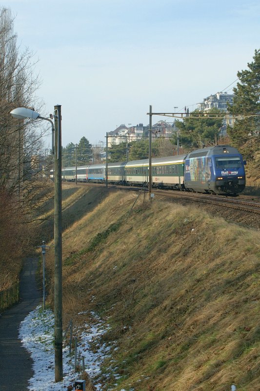Neben dem bunten IR nach Brig mit der Re 460 005-3 faszinierte mich auch die alte Holzmasten-Strassenlampe links im Bild. Das Bild entstand beim Kilometer 1.3, kurz nach der Ausfahrt des Bahnhofs Lausanne Richtung Wallis am 3. Februar 2009.