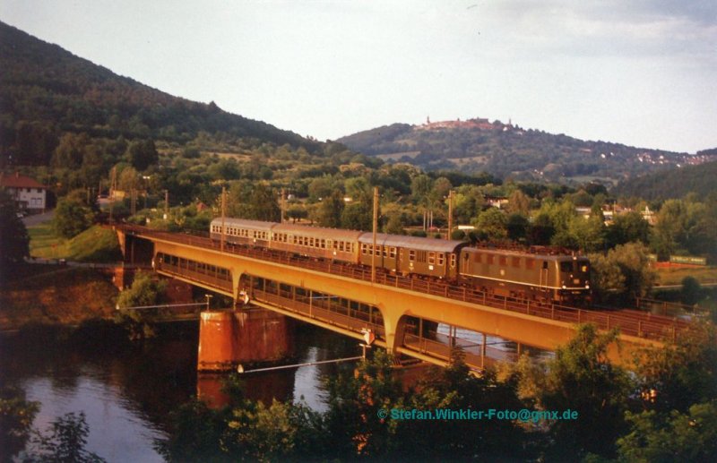 Neckarbrcke in Neckargemnd im Sommer 1989. Im Abendlicht zieht eine 141 einen Nahverkehrszug (damals hiess das noch so) ber den Fluss. Hinten grsst der Dilsberg. Gute alte DB-Zeit.....

Abfotografierter Abzug meines Dia-Archivs.