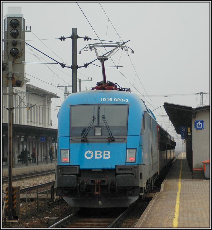 Nicht gerade perfekt ins rechte Licht gerckt. 1016 023 (Koyotolackierung) beim Halt mit einem Eilzug in Wien Htteldorf am 25.2.2006