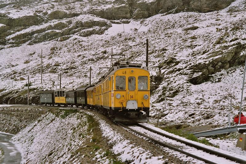 Nostalgischer Extrazug der Bernina-Bahn mit den beiden Triebwagen ABe 4/4 Nr. 34 und 30 (Baujahre 1908 und 1911) berquert am 11. Juli 2004 bei Bernina-Hospiz den hchsten Punkt der Linie auf ber 2200 m..M. Gut zwei Stunden nach diesen eisigen Temperaturen stand der Zug bei sommerlicher Wrme im italienischen Tirano!