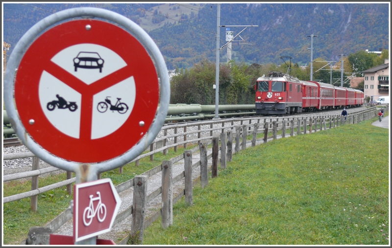 Nur Fahrradfahrer und die Bahn haben freie Fahrt. RE1228 mit Ge 4/4 II 621  Felsberg  bei Igis. (25.10.2009)