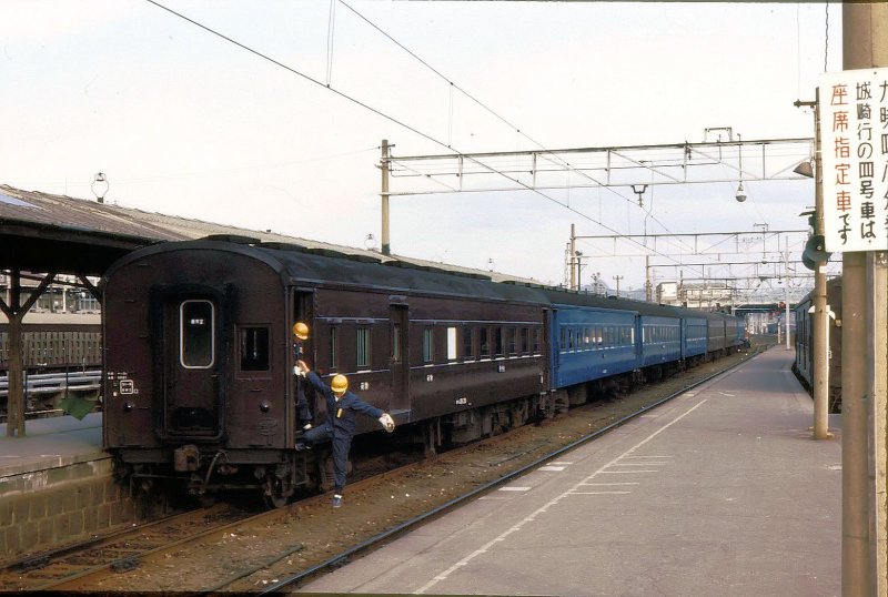 O-HA-NI 36 - Altbau-Personenwagen: 30 solche Wagen mit Personen- (HA) und Gepäck- (NI) abteil entstanden 1955/56 (Drehgestelle 1958 ersetzt). Hier steht ein Zug mit O-HA-NI 36 28 (オハニ36 28) am Schluss in Himeji, 14.Februar 1977. 