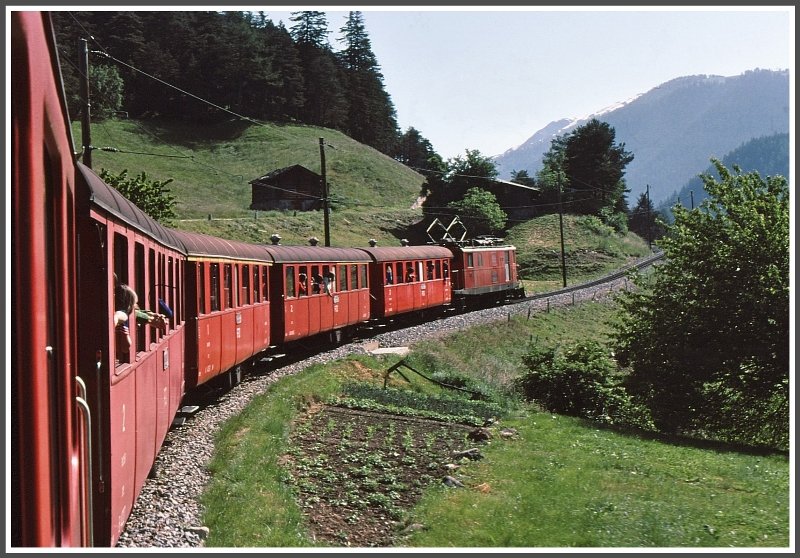 Oberhalb von Grengiols kmpft sich eine HGe 4/4 mit einem stattlichen Regionalzug (damals hiess es noch Personenzug) einen Zahnstangenabschnitt hoch Richtung Furka. (Archiv 06/77)