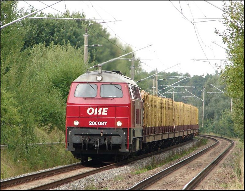 OHE 200087 mit seinem Holzzug aus Rostock-Bramow  bei der durchfahrt vom Hp Papendorf. 27.8.06
