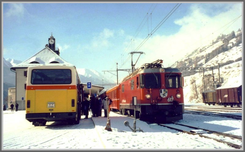 Optimale Verkehrsverknpfung in Scuol-Tarasp. Ge 4/4 II 617  Ilanz  ist soeben mit dem RE aus Chur eingetroffen, wo die meisten Passagiere in die Postbusse umsteigen, da der Bahnhof etwas ausserhalb des Zentrums liegt. Zudem werden von dieser Endstation aus viele Tler und Drfer mit Postbussen erschlossen. (Archiv 12/99)