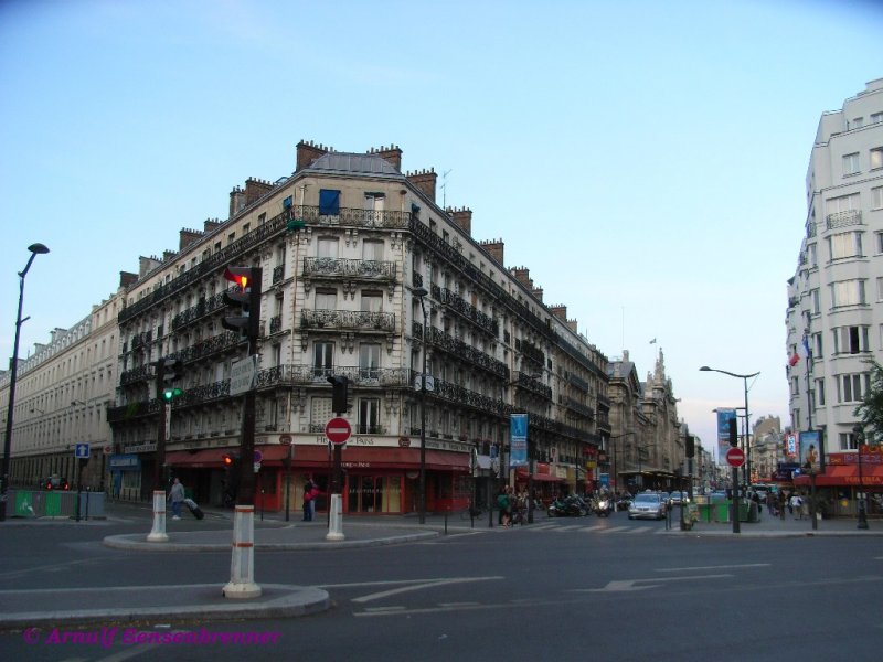 Pariser Straenflucht mit der Hauptfront des Gare du Nord.
Der erste Bahnhof an dieser Stelle wurde 1846 eingeweiht. Da dieser sehr schnell den Verkehrsansprchen nicht mehr gewachsen war, wurde von 1861-1865 an seiner Stelle ein Neubau errichtet. Die Fassade ist 180 m lang und hat eine Hhe von 43 m.
Bedingt durch den weiter rapide zunehmenden Verkehr (insbesondere den Vorortverkehr) wurde dieser Bahnhof 1875, 1889, 1900 sowie in den 1930er und 1960er Jahren und auch fr den TGV-Verkehr nach Norden und Grobritannien laufend erweitert und ausgebaut.
Mit 180 Millionen Reisenden (inklusive Nahverkehr) pro Jahr gilt der Gare du Nord als der am meisten frequentierte Personenbahnhof Europas. 
23.06.2007
