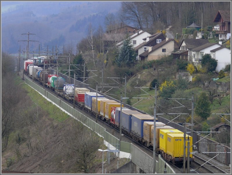 Passend zu den zarten Frhlingsfarben rollt ein bunter Gterzug zwischen Lrmschutzwnden bei Brugg AG Richtung Bzberg und Basel. (18.03.2008)