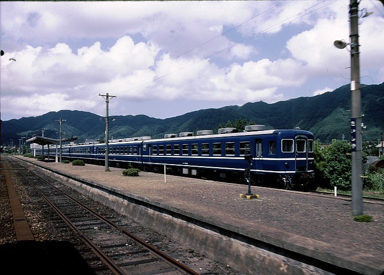 Personenwagen Serie 12. 1969-1978 603 Wagen gebaut für Gruppenreisezüge (billiger als Triebwagen;auch mit Güterzuglok einsetzbar dank Dieselgenerator).Heute einige noch vorhanden für Event- und Dampfextrazüge.Bild:(vorn)SU-HA-FU 12 45 (スハフ12 45)
in Izumo Taisha (8.Sep.1983); die Wagen haben Pilger zum Grossen Götterschrein von Izumo gebracht. Heute kommen Pilger in Bussen... Strecke 1990 stillgelegt.    
(ス=SU schwerer Wagen(hier wegen Generator)37,5-42,5 t;ハ=HA gewöhnl.Sitzwagen;フ=FU Personalabteil)