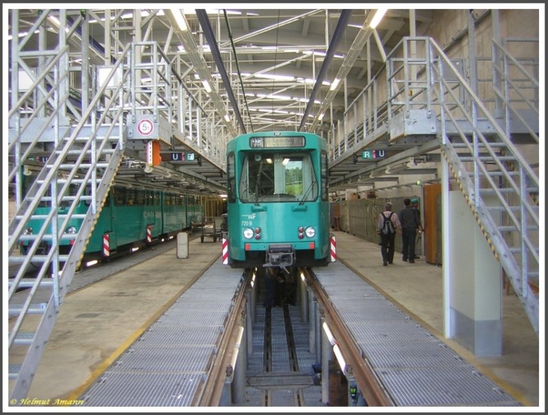 Ptb-Triebwagen 720 im Bild links etwas verdeckt und Ptb-Triebwagen 745 am 25.08.2007 in der Werkstatthalle des Betriebsbahnhofes Ost, bei einer Besichtigung mit F�hrung durch den Betriebsbahnhof im Rahmen einer Sonderfahrt des Vereins Historische Stra�enbahn der Stadt Frankfurt am Main e. V. aufgenommen. Deutlich erkennbar sind die erh�hten Arbeitsb�hnen f�r Instandhaltungsarbeiten an den elektrischen Bauteilen auf dem Dach und dem Stromabnehmer. Das ist besonders bei den Niederflurfahrzeugen von Bedeutung, die konstruktionsbedingt den gr��ten Teil der elektrischen Aus�stung auf dem Dach haben.