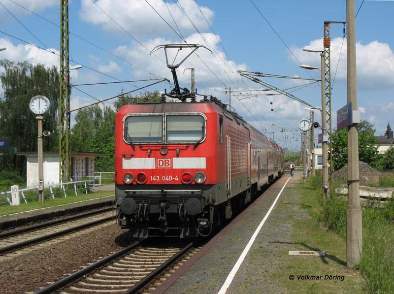 Pnktlich 12:00 Uhr schiebt 143 040 den von Dresden kommenden RE 17226 nach Hoyerswerda; die Bahnsteiguhren, die Leuchten und das Wartehuschen sind noch passend zur Baureihe 143 (auer Farbgebung) im Reichsbahn-Flair der DDR-Zeit  - Radebeul-Naundorf, 02.06.2006
