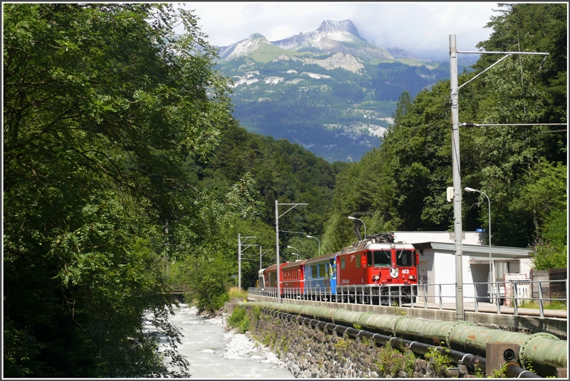 R1437 mit Ge 4/4 II 613  Doamt/Ems  fhrt bei Sassal der Plessur entlang. Im Hintergrund der immer noch leicht verschneite Calanda.
(20.07.2009)