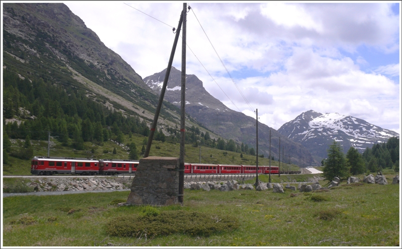 R1646 mit ABe 4/4 III 53  Tirano  und 54  Hakone  fhrt bei Bernina Suot Richtung Morteratsch. Im Hintergrund der Piz Alv 2975m und der Piz Lagalb 2893m. Im Vordergrund verstrkte Masten gegen Staublawinen und Panzersperren aus Felsblcken quer ber den Talgrund. (03.07.2009)
