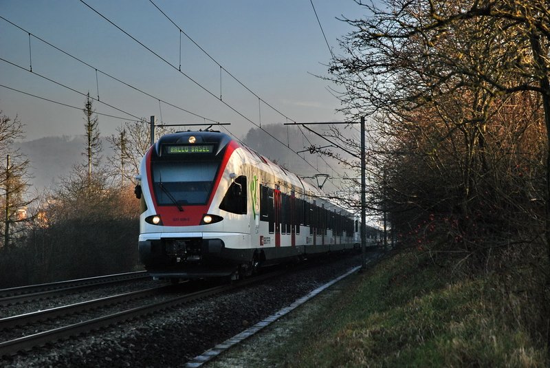 RABe 521 026-5.  HALLO BASEL  steht auf dem unglaublich langen Triebzug. Es knnten ca. 6 bis 8 Flirt-Kompositionen zusammengekoppelt gewesen sein. Ich habe sie leider nicht gezhlt, weil ich zu berrascht ber diesen einmaligen Anblick war. Wahrscheinlich war es eine berfhrung von nagelneuen Triebzgen nach Basel. Zeihen (Aargau) am 14.12.2006