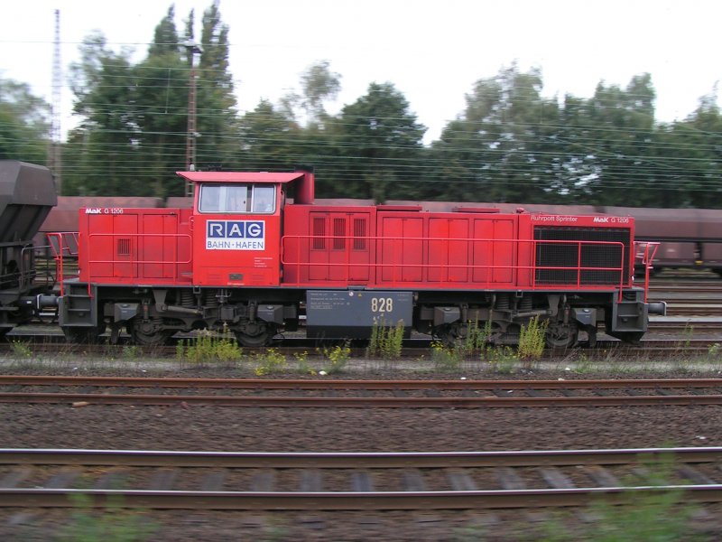 RAG (heute RBH) 828 steht mit Kohlewagenzug am Haken in Gladbeck am 02.10.2004. Diese Lok ist bezglich Ihrer Lackierung etwas Besonderes bei der RAG / RBH, denn fast ausschlielich alle anderen Lokomotiven dieses Typs sind in orange lackiert. Dieses Bild wurde aus einem fahrenden Zug mit 78 468 als Zuglok gemacht.