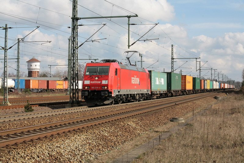 Railion mit der 185 228-4 zieht hier einen Containerzug durch Ludwigslust nach Hamburg. Im Hintergrund der Wasserturm der WEMEG. 27.03.2008