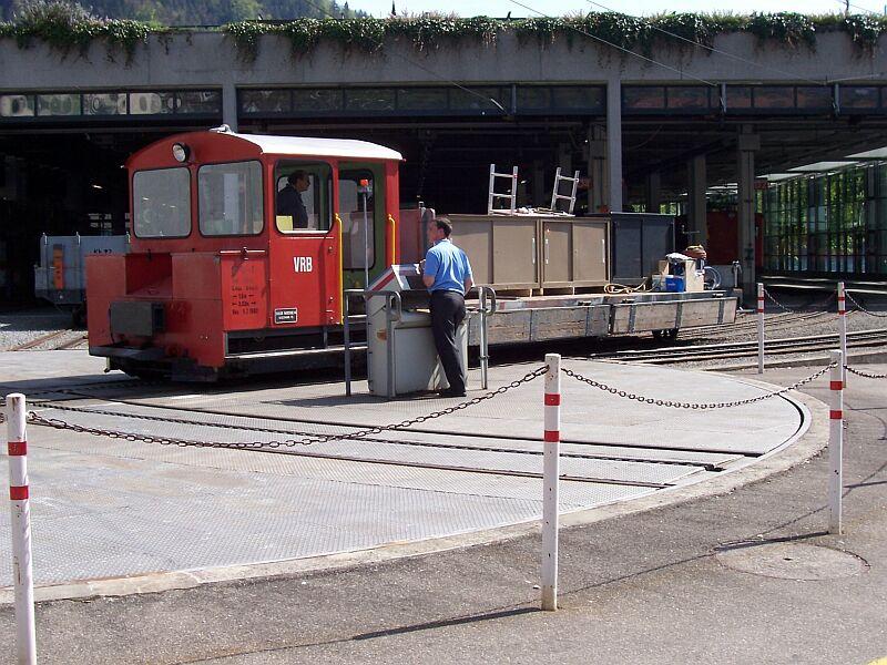 Rangier-Traktor Ta 2/2-1 mit Niederbordwagen Kk 21 beladen mit Brombeln am 30.04.2005 auf der Drehscheibe in Vitznau, dahinter die groe Fahrzeughalle.