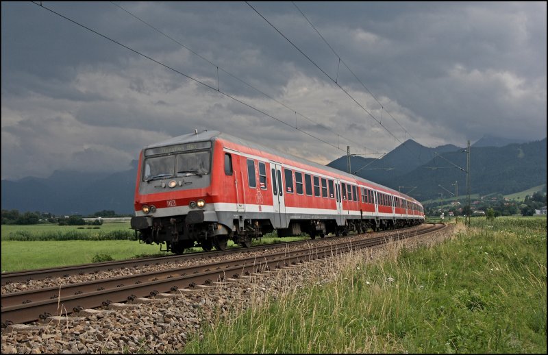 RB 30032 ist von Salzburg Hbf nach Mnchen Hbf unterwegs und flchtet bei Bernau am Chiemsee vor den dunklen Wolken. (09.07.2008)