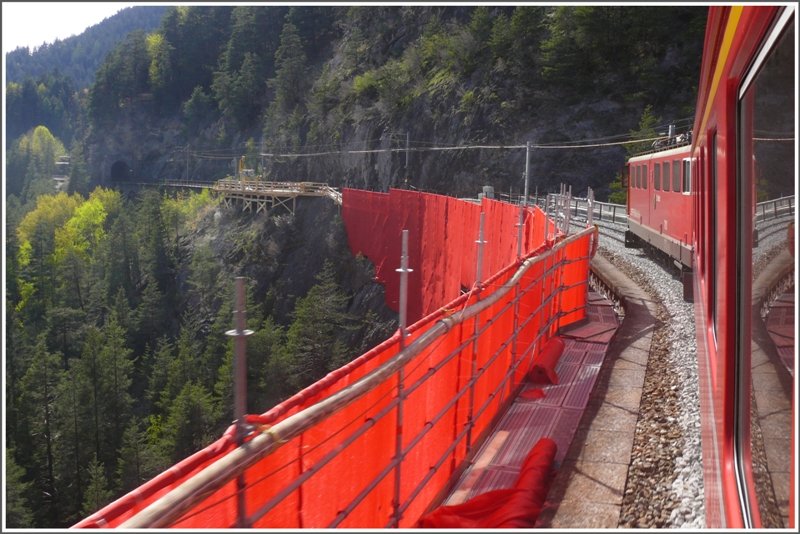 RE 1156 mit Ge 6/6 II 703  St.Moritz  berquert soeben den frisch verpackten Landwasserviadukt bei Filisur. (06.05.2009)