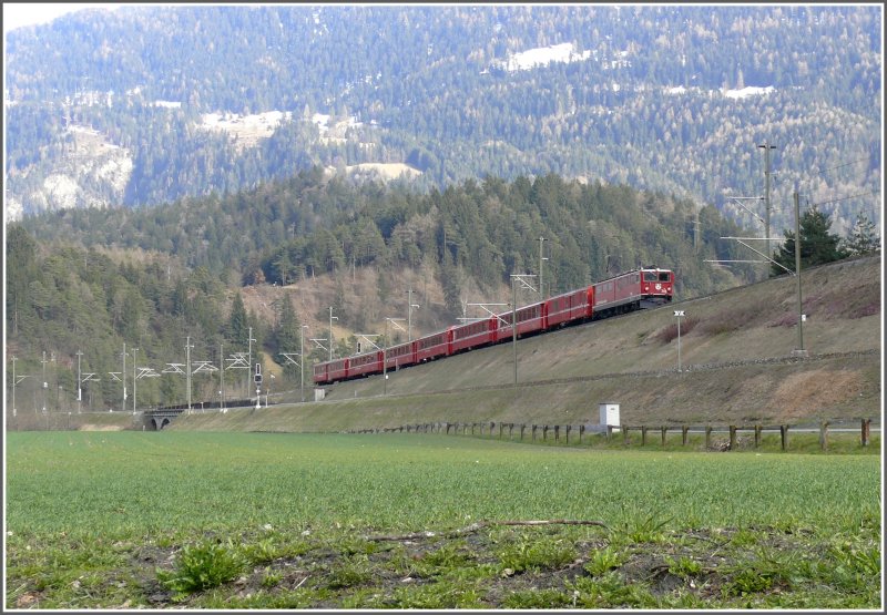 RE 1157 mit Ge 6/6 II 704 hat soeben den Hinterrhein bei Reichenau-Tamins berquert und befindet sich jetzt auf dem Weg nach St.Moritz. Das Geleise im Vordergrund ist die Strecke ins Oberland nach Disentis. (05.04.2008)