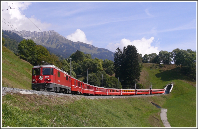 RE 1244 aus (Scuol)Ardez hat soeben den neuen Saaser Tunnel verlassen. Zuglok ist die Ge 4/4 II 627  Reichenau-Tamins . Das alte Tunnelportal befindet sich links des zweitletzten Wagens. (24.09.2009)