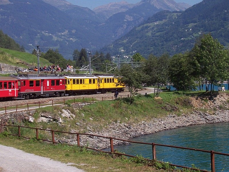 RE 1642 Tirano - St.Moritz am 15.07.2007 am Lago di Poschiavo zwischen Miralago und Le Prese. In den beiden gelben Triebwagen waren keine Fahrgste, im roten ja, ob die alten und neueren Triebwagen von einen Triebwagenfhrer gesteuert werden knnen, habe ich nicht heraus gefunden.