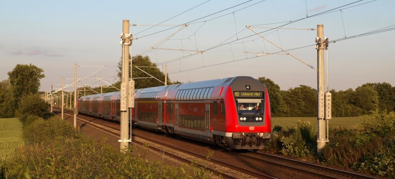 RE 21432 nach L�beck Hbf entflieht am 13.06.09 dem Sonnenuntergang Richtung L�beck Hbf. Die Beiden Sonnengenie�er im Steuerwagen freuen sich sicherlich schon auf ihren wohlverdienten Feierabend.