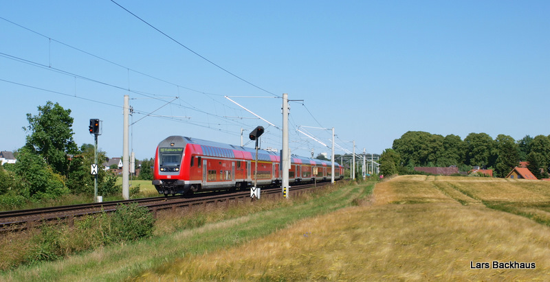 RE 21575 nach Hamburg Hbf durchf�hrt an einem sonnigen Nachmittag die leicht h�gelige Feldlandschaft hinter Reinfeld (Holst.) und wird in wenigen Minuten Bad Oldesloe erreichen. Aufgenommen am 24.06.09.