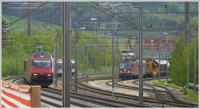 RE 3834 nach St.Gallen ist ausnahmsweise mit einer Re 460 bespannt. Re 460 015-1 hat soeben die neue RhB Brcke in Untervaz-Trimmis unterquert, rechts davon im Holcim Anschlussgleis macht sich ein Gterzug bereit zur Abfahrt. (30.04.2009)
