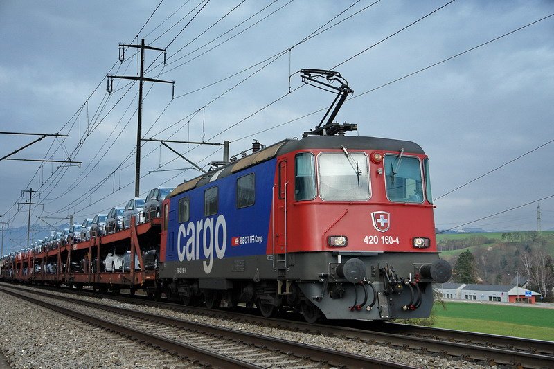 Re 420 160-4. Die Lok sieht ganz neu aus. Die vielen VW Fahrzeuge sind es ganz bestimmt. Ist die Bezeichnung vorn auf der Lok auch anders, als frher? Wer wei mehr darber? Bei Frick (Kanton Aargau) am 29.1.2007