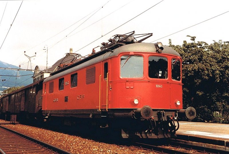 Re 4/4 I 10043 in Rot, aber noch ohne weissen Trennstreifen mit Regionalzug 4876 in Grenchen Nord am 14. September 1984.
(Gescanntes Foto)