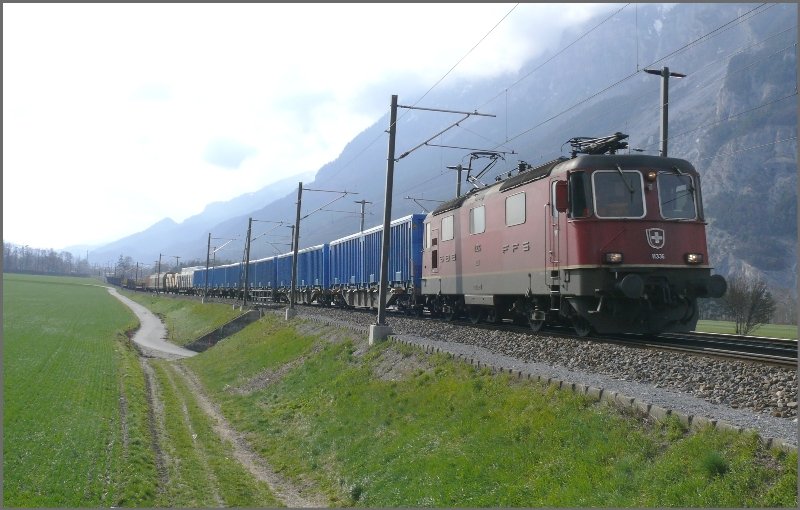 Re 4/4 II 11336 mit enem langen Gterzug auf dem Dreischienengleis im Anstieg zwischen Felsberg und Chur West. Die blauen Wagen enthalten Holzschnitzel der Sgerei Stallinger, die brigens diese Woche den Besitzer endgltig gewechselt hat. (31.03.2008)