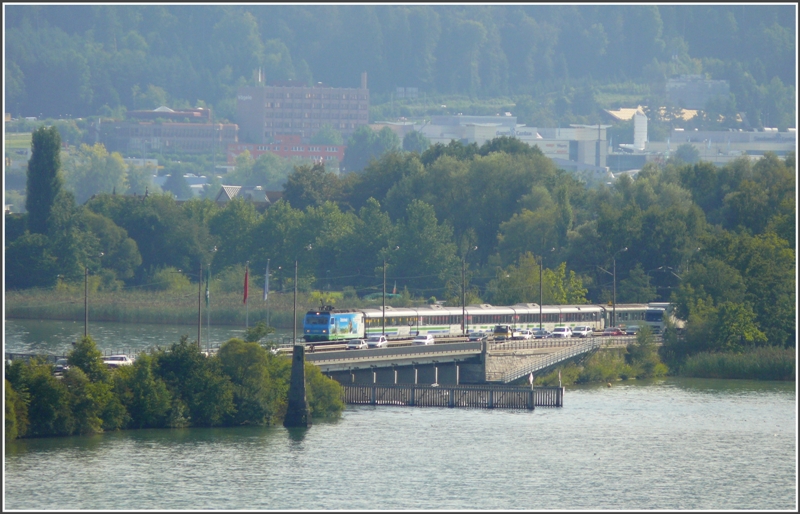 Re 456 mit Voralpenexpress berquert den Seedamm bei Rapperswil. Die Aufnahme entstand vom Rosengarten beim Schloss. (18.08.2009)