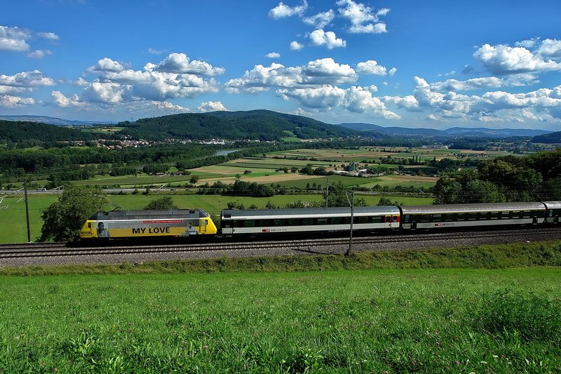 Re 460 028-4. Ein wunderschner Tag mit herrlichen Wolken, einem weiten Blick ins Aargauer Land und dazu ein InterRegio mit der neuen gelben  Western Union  Lok. Da hat sich das lange Warten doch gelohnt und man fhrt zufrieden nach Hause. Im Aargau am 30.7.2007