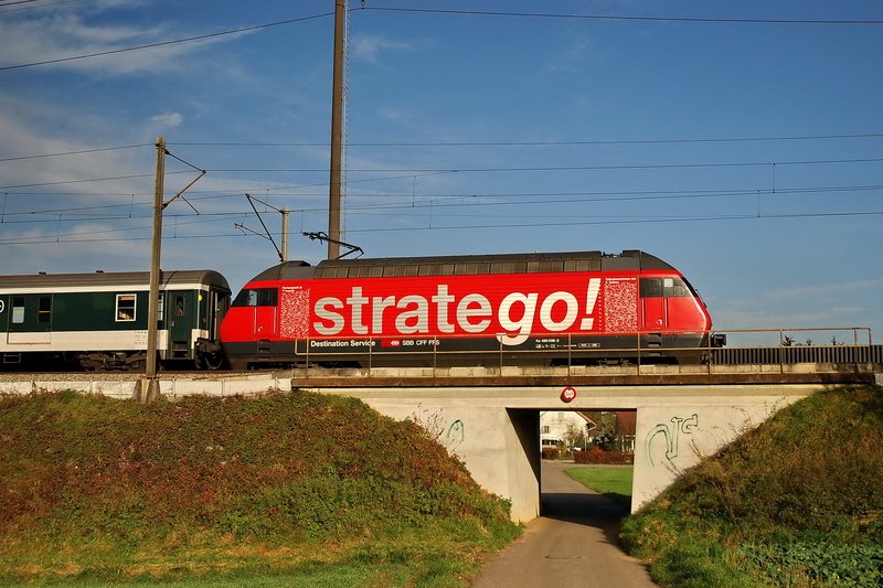 Re 460 038-3. Die feuerrote  stratego  Lok berquert eine kleine Brcke bei Oeschgen (Kanton Aargau). Der InterRegio nach Zrich hat noch eine Stunde Fahrzeit vor sich. 26.11.2006