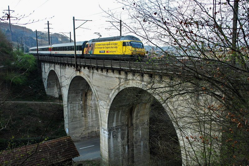 Re 460 042-5. Der InterRegio und seine gelbe  Western Union  Lok befinden sich hier auf der mchtigen Strassenbrcke in Mumpf (Aargau). Fr weitere Fotos muss ich wohl ein paar Bume fllen, um bessere Sicht zu bekommen. Ist nur ein Scherz. 3.4.2007