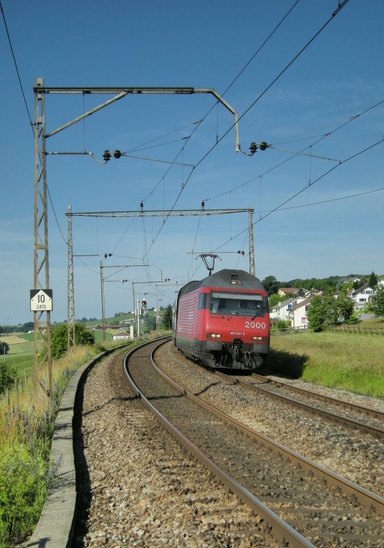 Re 460 mit IC bei Neyruz im sanften Morgenlicht, eingerahmt von alten SBB -Fahrleitungsmasten am 19. Juni 2008.