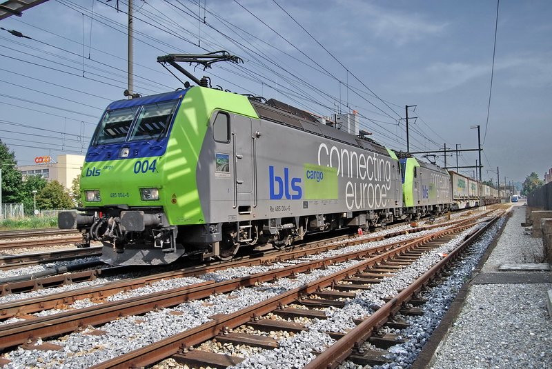 Re 485 004-6 der BLS. Mit einer Schwesterlok rollt der Gterzug, bei schnem Fotolicht, durch den Bhf. Pratteln (Kanton Baselland Schweiz) am 23.9.2006 