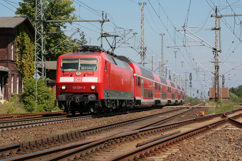 RE1 mit der 120 204 von Rostock nach Hamburg fhrt gerade durch den Bahnhof Holthusen. 25.05.2009 