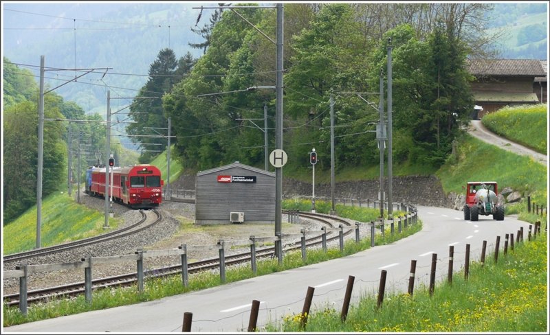 RE1044 aus Davos mit Steuerwagen 1756 an der Spitze durchfhrt die Dienststation Fuchsenwinkel zwischen Furna und Schiers. Im Moment stinkts im Prttigau berall, Schuld daran sind die Bauern mit ihren Gllenfssern (derjenige auf der Strasse hat sein Fass soeben entleert und das in nchster Nhe) (14.05.2009)