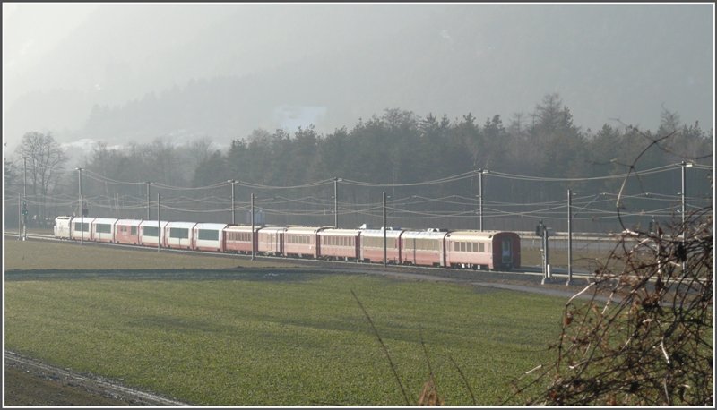 RE1153 mit Glacier Express Abteilung zieht Richtung Felsberg ins schrg einfallende Abendlicht. (30.01.2009)