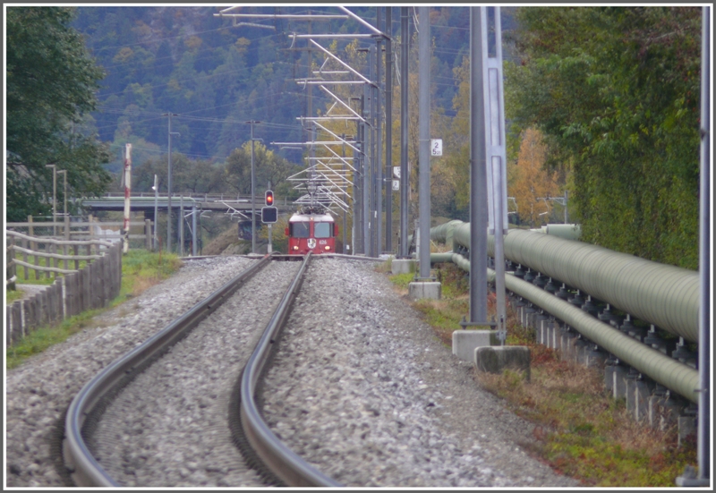 RE1237 mit Ge 4/4 626  Malans  nhert sich der Station Igis und ist wegen der  Erdkrmmung  erst halb zu sehen. (25.10.2009)