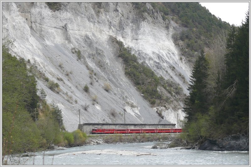 RE1240 mit Ge 4/4 II 626  Malans  passiert die riesige Schutthalde bei Trin, wo das Geleise durch eine hohe Schutzmauer vom unstabilen Hang getrennt wird. (17.04.2009)