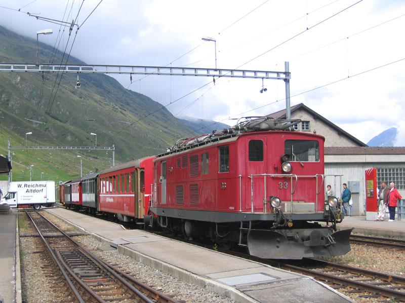 Realp, vor dem Abkuppeln vom Zug musste Hge 4/4 I FO 33 den Pantograph einziehen. Derweil wird aus dem am Ende des Zuges mitlaufenden Gterwagen das Gepck der Reisenden in den bereitstehenden LKW verladen. - 13.08.2005
