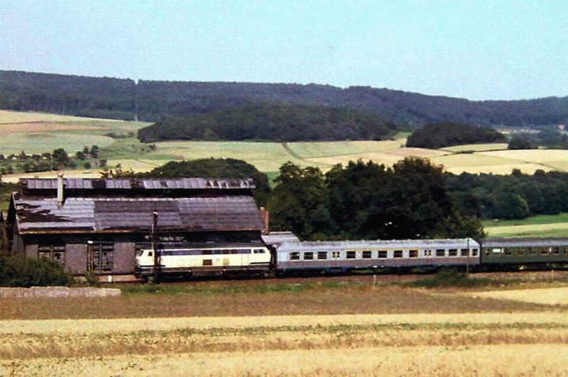 Reisezug aus Wetzlar bei der Einfahrt in Grvenwiesbach - rechts im Hintergrund ist das Fabrikgelnde am Hasselborner Tunnel zu erkennen - deutlich werden hier auch schon die Zerstrungen am Lokschuppen, 1. Hlfte der 1980iger Jahre.
