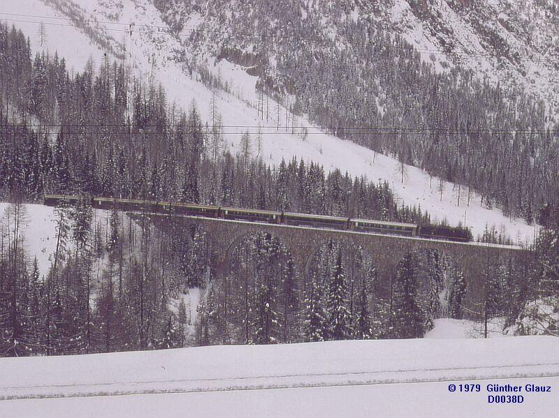 Reisezug fhrt talwrts ber den Viadukt Albula 1 - Mrz 1979. Die Strecke (ganz unten im Bild) kommt rechts vom Zwondra-Tunnel, geht links ber den Viadukt Albula 2 und einer Schleife am Gegenhang zum Viadukt Albula 1 und weiter nach rechts zum Toua-Tunnel.