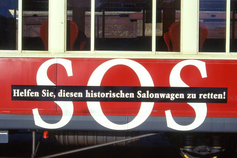 RhB - As 1144 am 09.07.1997 in Scuol - Historischer 1.Klasse Salonwagen 4-achsig - Detailansicht: Werbung: SOS, gescanntes Dia
