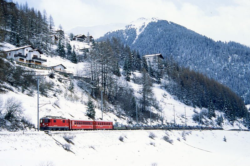RhB Autozug 958 von Samedan nach Thusis am 11.04.1998 bei Bergn mit E-Lok Ge 4/4 II 612 - B 2363 - B 2449 - Skl 8410 - Skl 8401 - Rw 8264 - Skpw 8416 - Rw 8216 - Rw 8231 - Rpw 8235 - Rpw 8237 - Rpw 8288 - Skl 8402. Hinweis: gescanntes Dia.
